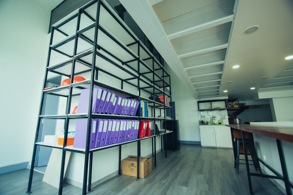 Modern office shelving unit organized with labeled binders